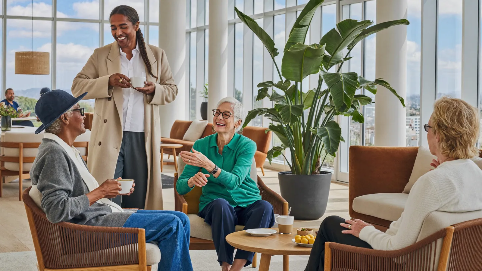 Independent seniors talking over coffee in a bright retirement community lounge