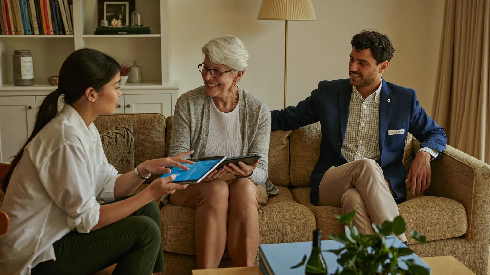 An advisor showing community options on a tablet to an older woman and her son