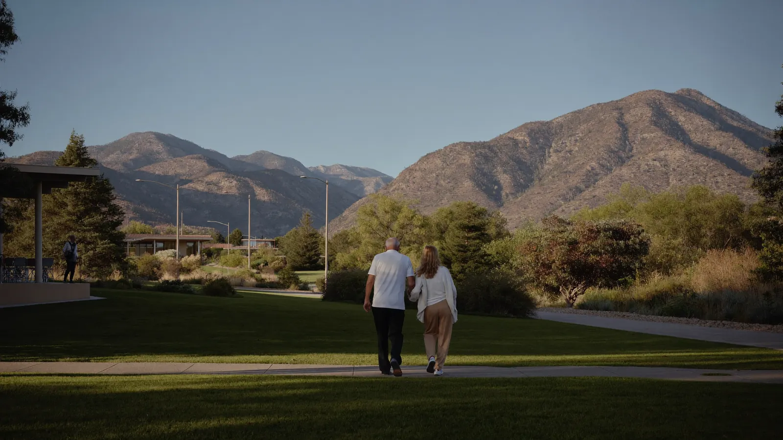 A family walking together outside a Colorado senior living community at golden hour
