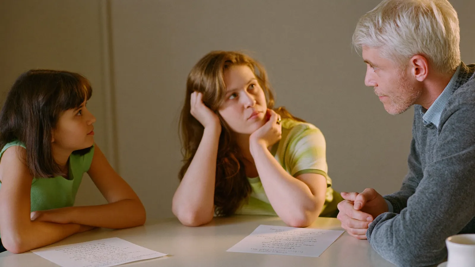 A daughter asking an advisor questions from a handwritten list on the table