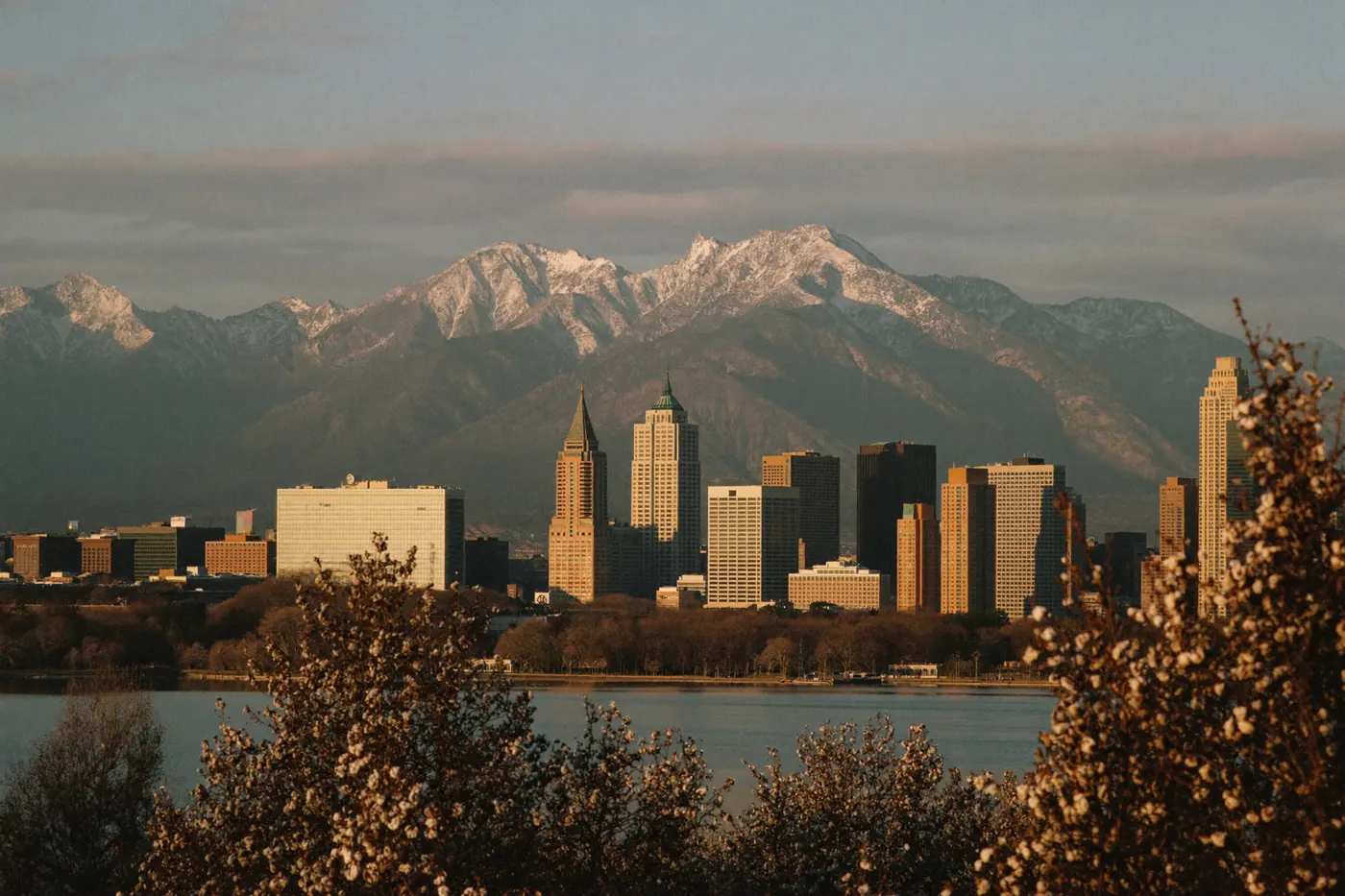 The Denver skyline at golden hour with the snow dusted Front Range behind it