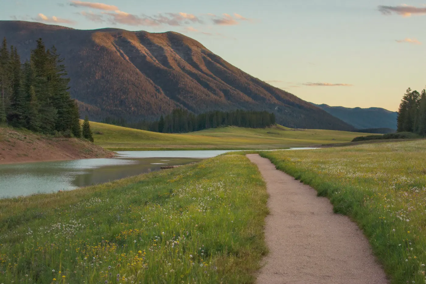 A walking path beside a Lakewood reservoir with Green Mountain rising behind it